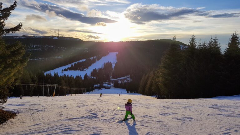 Kind auf Skihang gegen die Sonne blickend